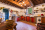 Kitchen, 16.50 sq.m. in exposed brick, terracotta and stone with work surfaces in granite, double sink in antique marble. Glimpse of the entrance to the 3 sq.m. store room